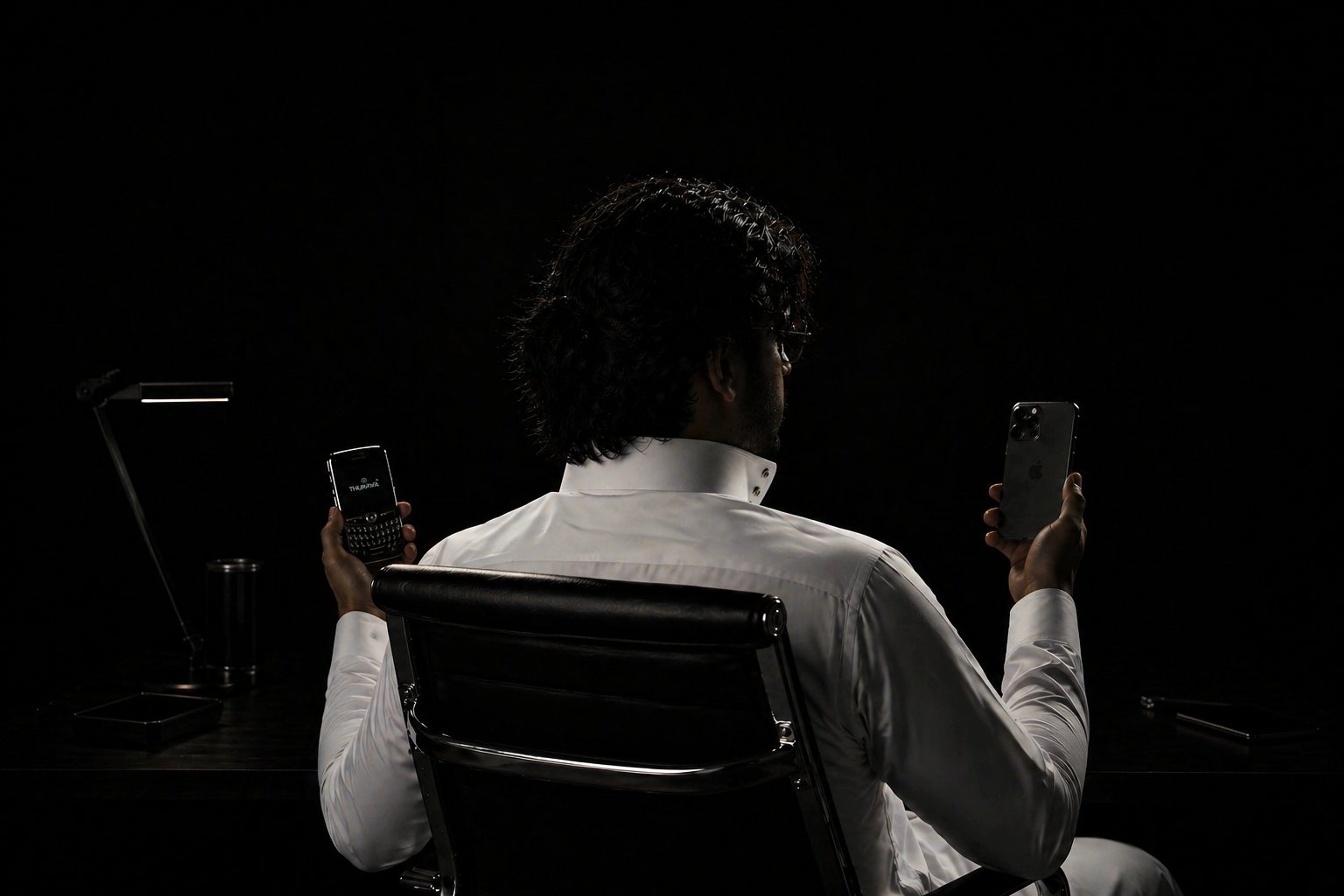 Omar Al Sumih seated in a dark studio workspace
